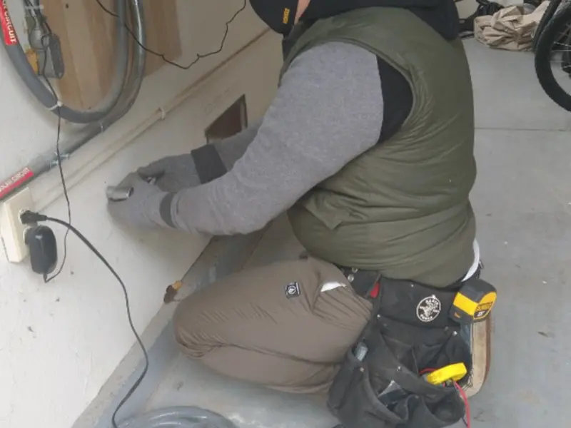 Electrician performing outlet wiring in a Tinton Falls garage